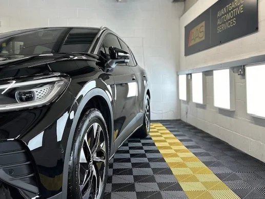Black SUV with a deep gloss finish after a detail, in the Avantgarde unit under the company sign